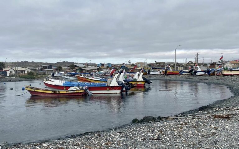 boats anchored offshore a stone-covered shore