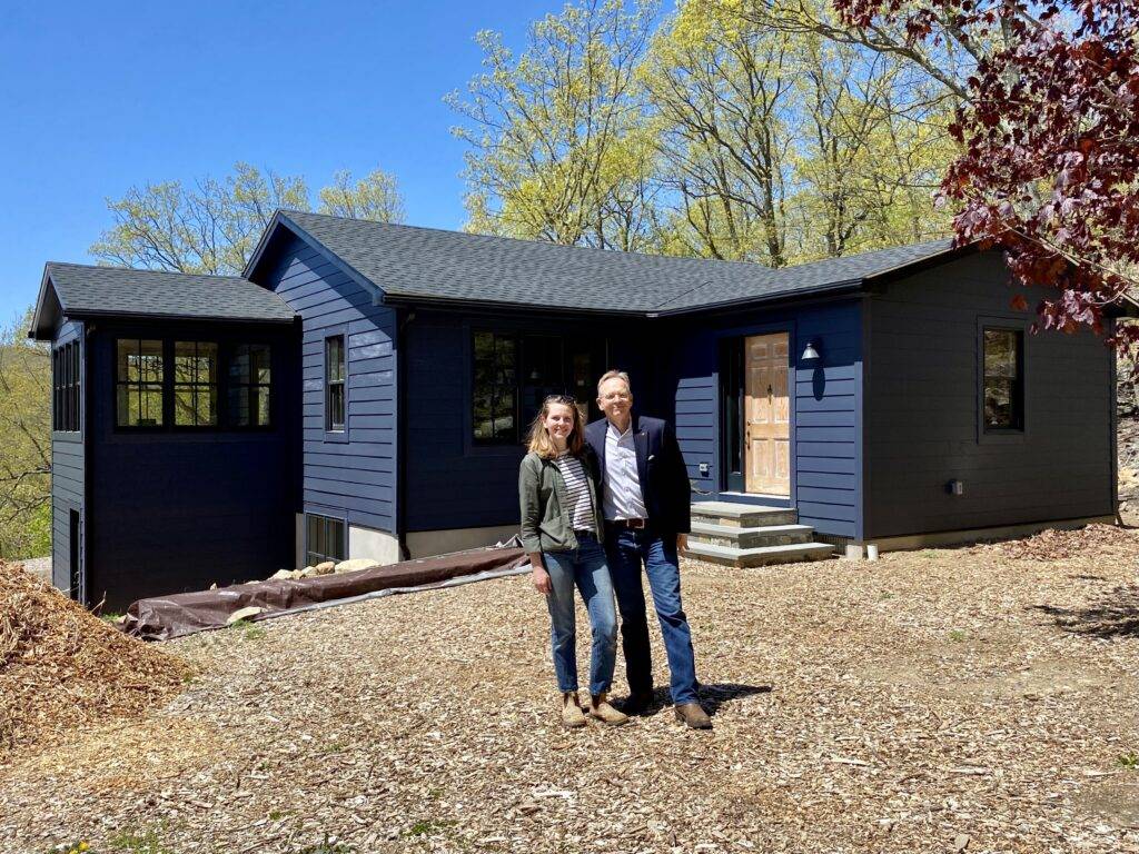 Bea and her father stand outside the newly renovated blue cottage.